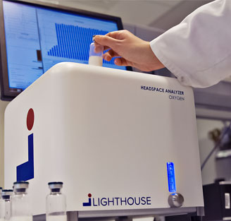 Lighthouse Instruments scientist setting sample vial into headspace analysis inspection system